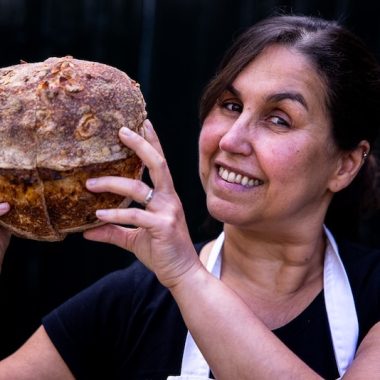Mulher com pão de fermentação natural nas mãos